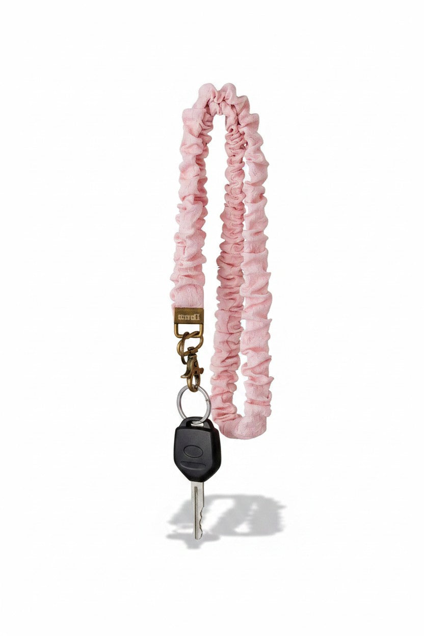 Doodlations Coffee Bar & Boutique light pink textured fabric lanyard with a metal clasp holding a car key