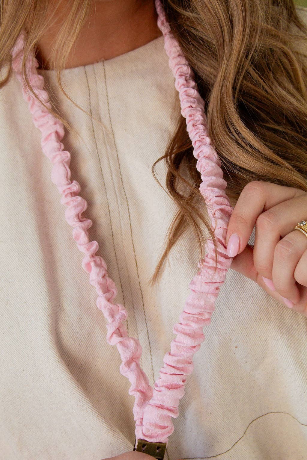 Doodlations Coffee Bar & Boutique light pink floral-textured fabric lanyard worn around the neck