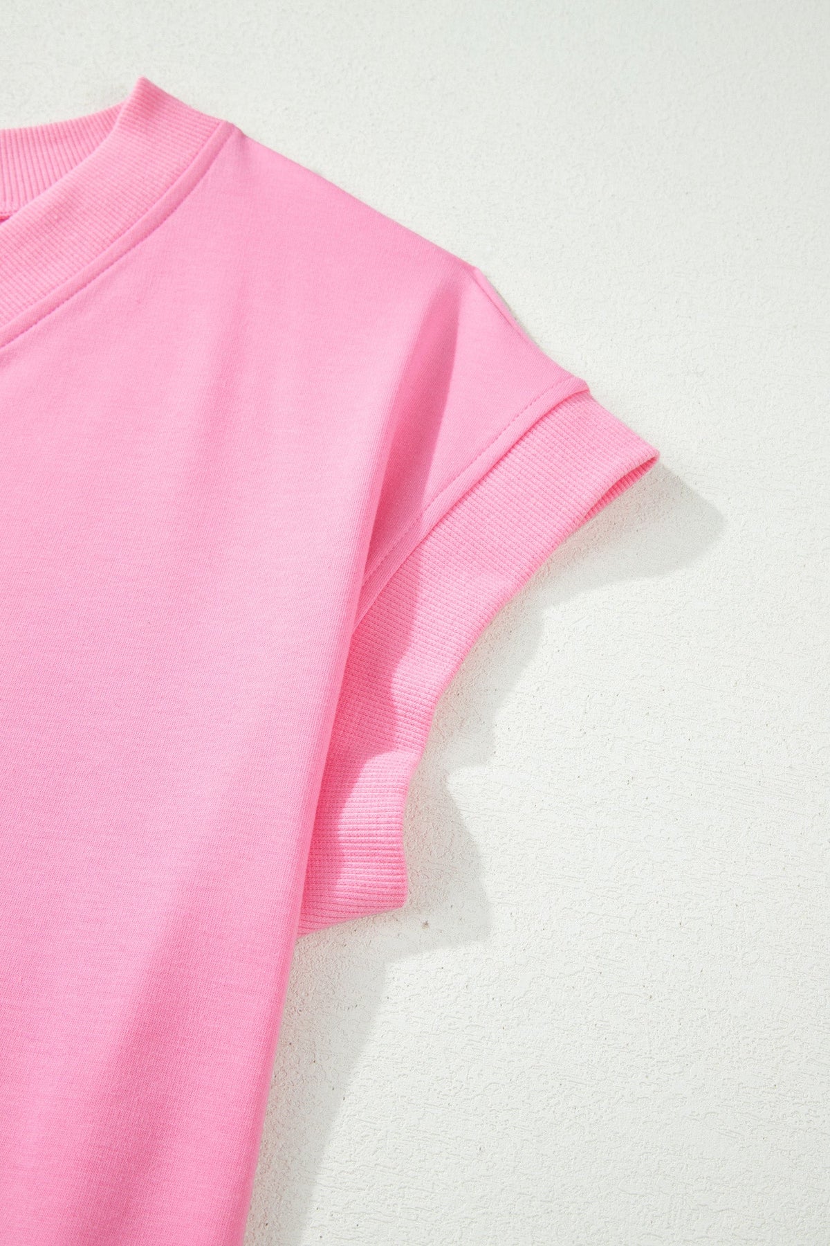 Doodlations Coffee Bar & Boutique pink V-neck lounge top with ribbed short sleeves on a textured white background
