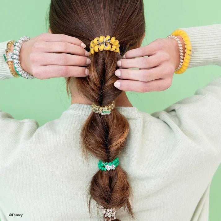 Doodlations Coffee Bar & Boutique Disney Pluto spiral hair ties in yellow, green, and clear worn in a braided ponytail
