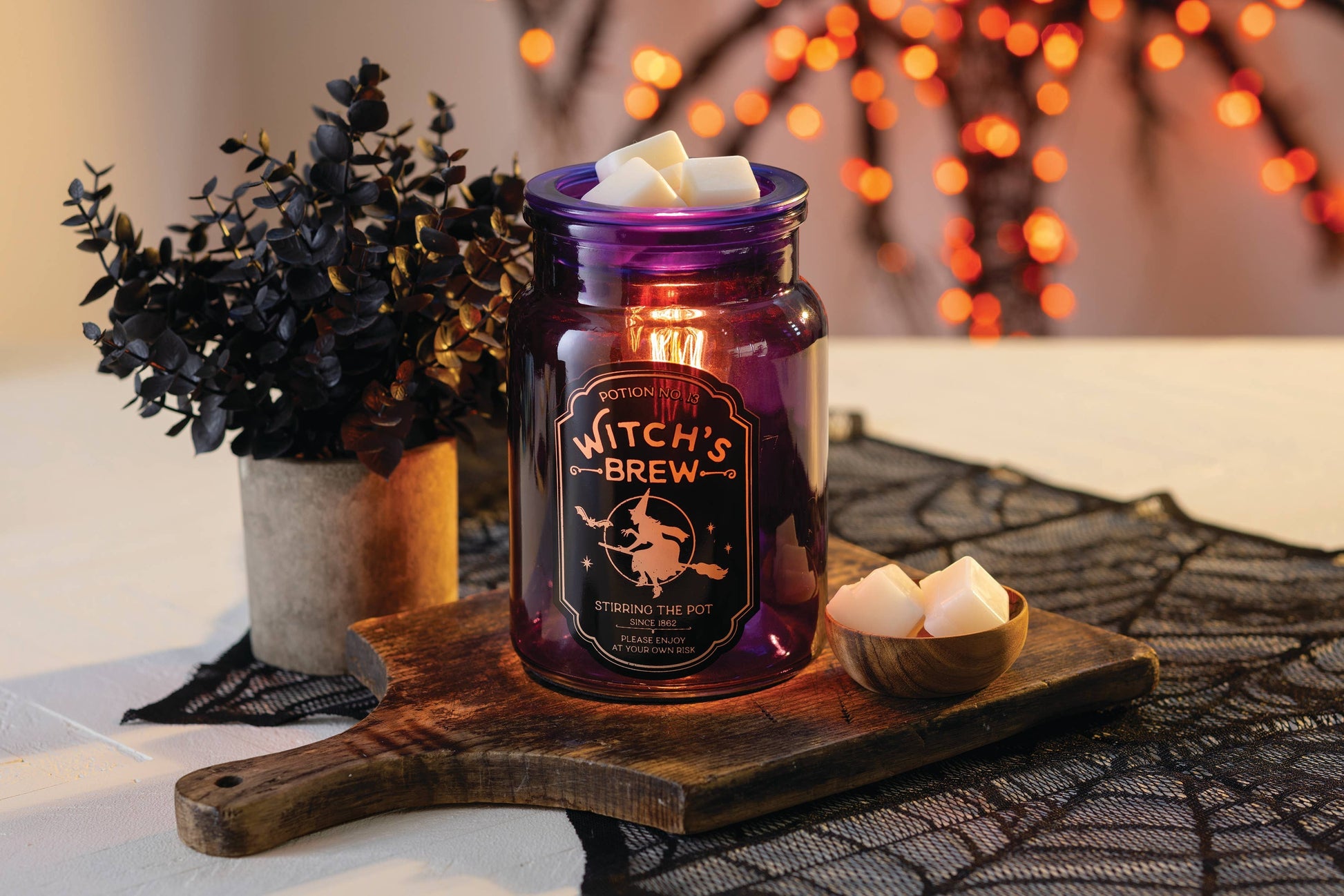 Doodlations Coffee Bar & Boutique purple glass Witch's Brew wax warmer with vintage apothecary-style Halloween art.