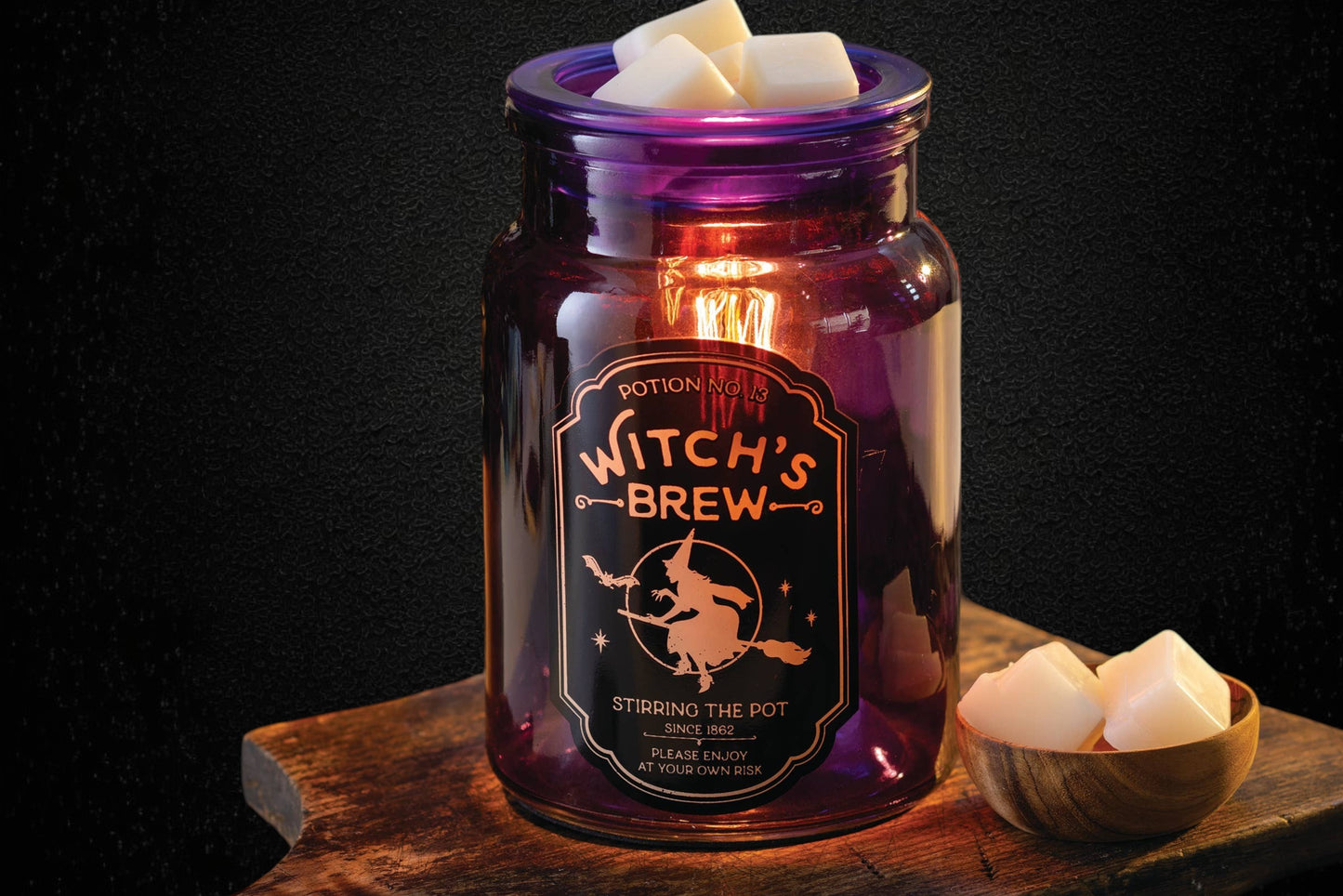 Doodlations Coffee Bar & Boutique purple glass Witch's Brew wax warmer with vintage apothecary-style witch artwork.
