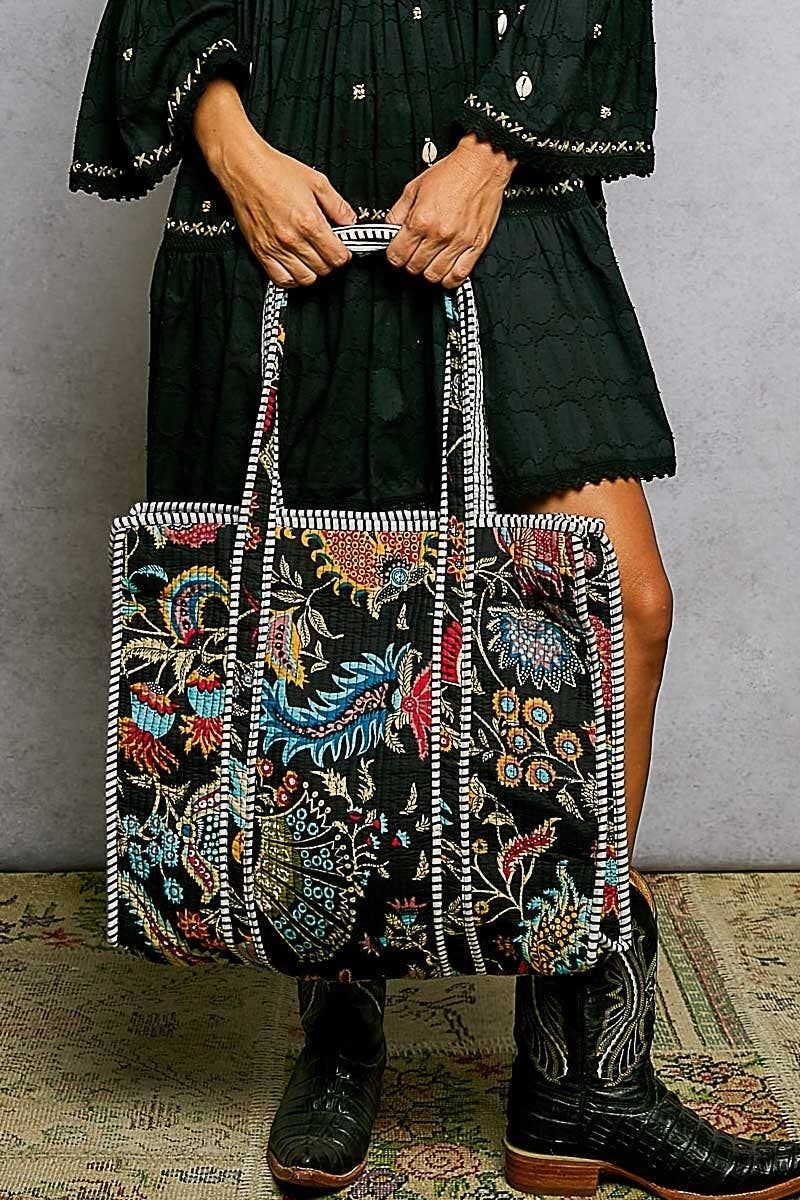 Doodlations Coffee Bar & Boutique black quilted tote bag with colorful floral print and striped binding accents.