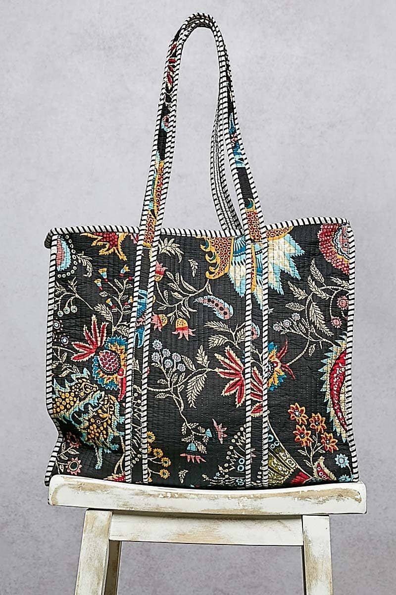 Doodlations Coffee Bar & Boutique black quilted tote bag with floral print and striped binding accents.