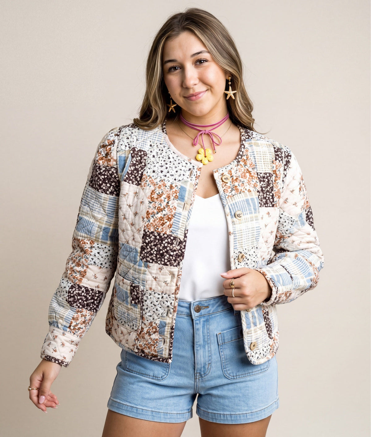 Doodlations Coffee Bar & Boutique quilted patchwork jacket with floral prints and button front on a smiling woman