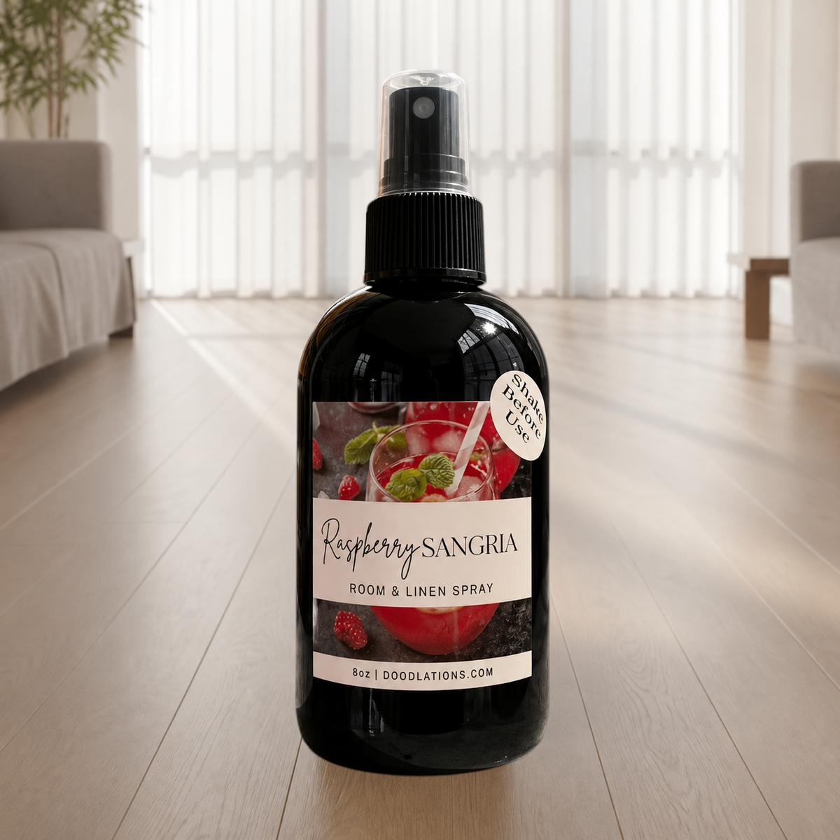 Doodlations Coffee Bar & Boutique Raspberry Sangria room and linen spray in a black bottle with a fruit-themed label.