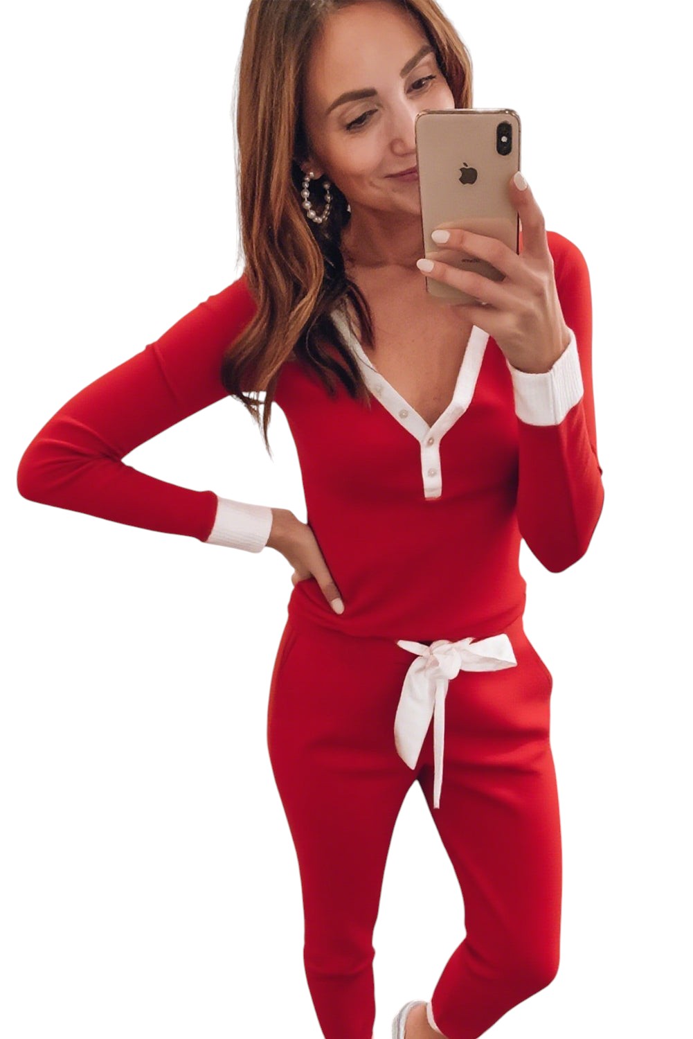 A woman wearing a Doodlations Coffee Bar & Boutique fiery red pajama set with white contrast trim and a knot waist.