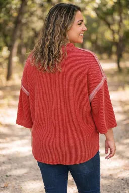 Doodlations Coffee Bar & Boutique fiery red ribbed tunic with bracelet sleeves and twist detail worn by a woman