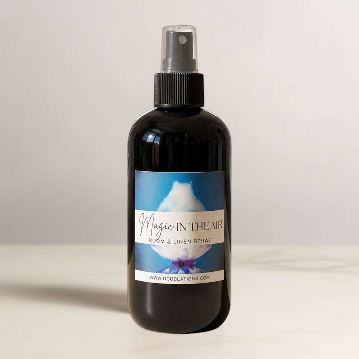 Doodlations Coffee Bar & Boutique Magic in the Air room and linen spray in a black bottle with a floral label