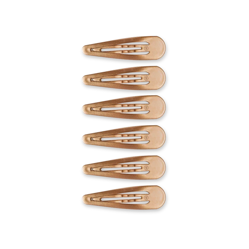 Six metallic rose gold TELETIES Snap Clip hair clips arranged vertically against a black background.