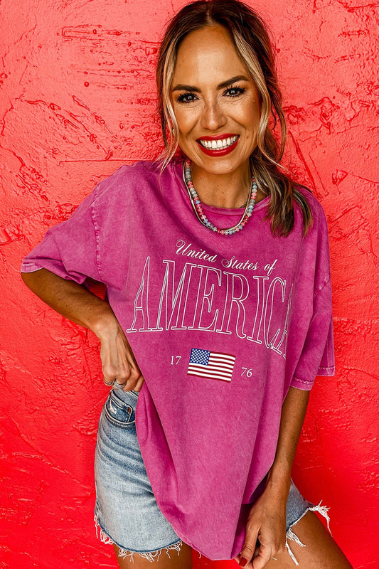 Doodlations Coffee Bar & Boutique rose red mineral wash cotton graphic tee with "AMERICA 1776" and US flag graphic.