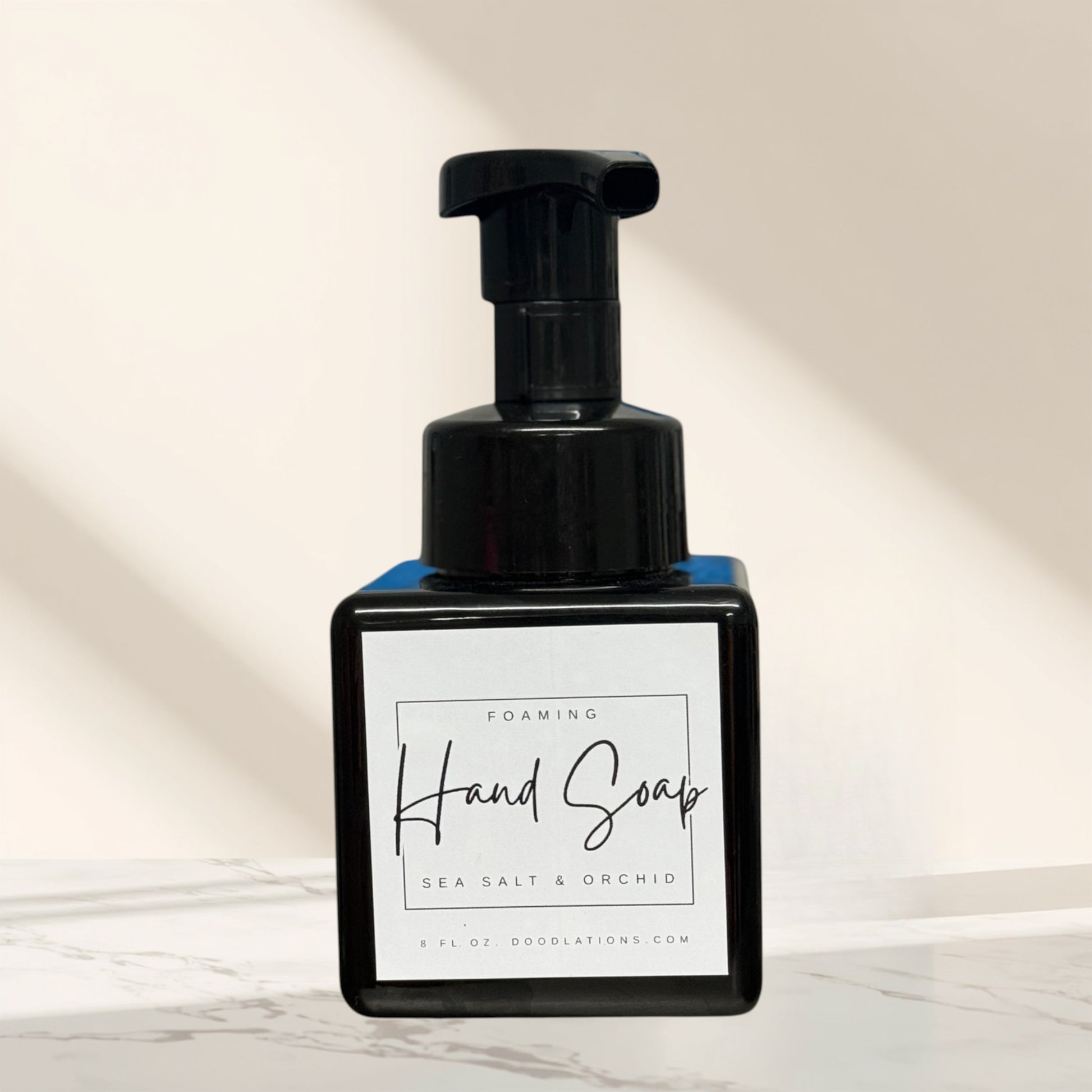 Doodlations Coffee Bar & Boutique Sea Salt & Orchid foaming hand soap in a black square bottle with a white label.