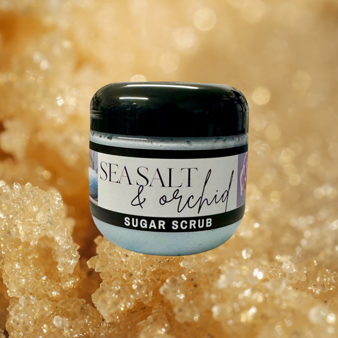 Doodlations Coffee Bar & Boutique Sea Salt & Orchid Sugar Scrub in a clear jar with a black lid, light blue scrub inside.