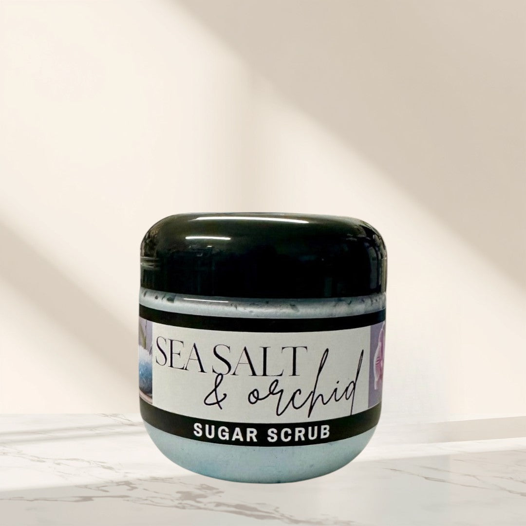 Doodlations Coffee Bar & Boutique Sea Salt & Orchid Sugar Scrub in a clear jar with a black lid, light blue scrub inside.