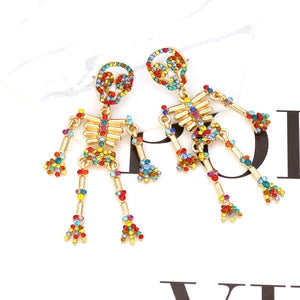 Doodlations Coffee Bar & Boutique articulated skeleton dangle earrings with colorful rhinestones on gold-tone alloy