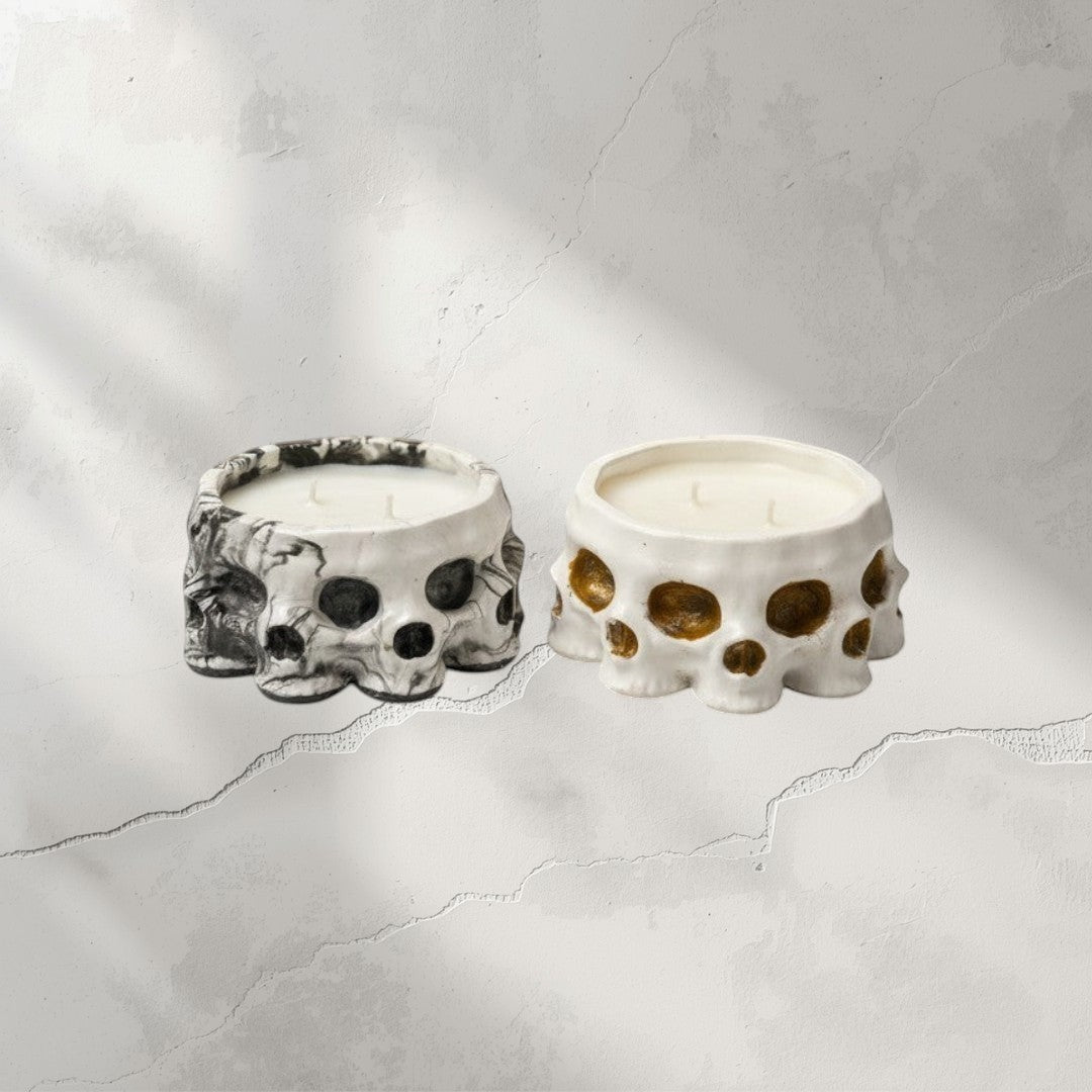 Doodlations Coffee Bar & Boutique Skull concrete candles, one black and white marbled, one white with gold accents. Soy blend candle.