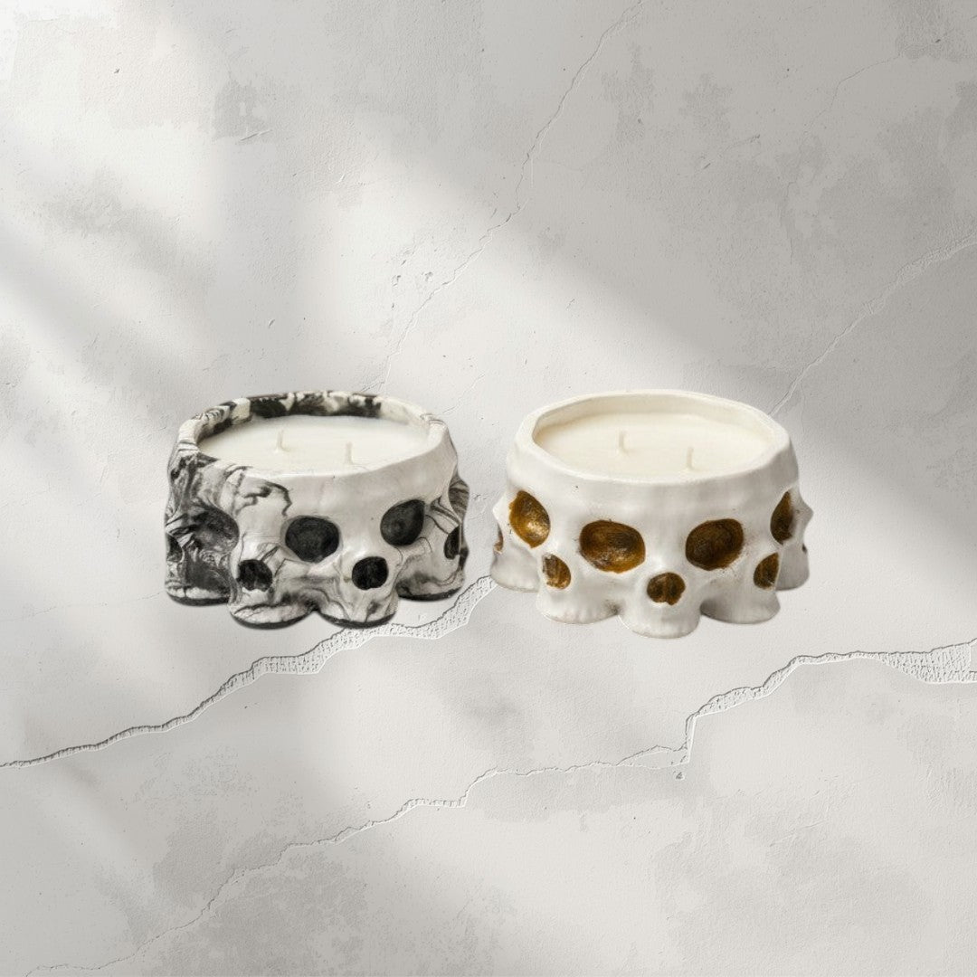 Doodlations Coffee Bar & Boutique Skull concrete candles, one black and white marbled, one white with gold accents. Soy blend candle.
