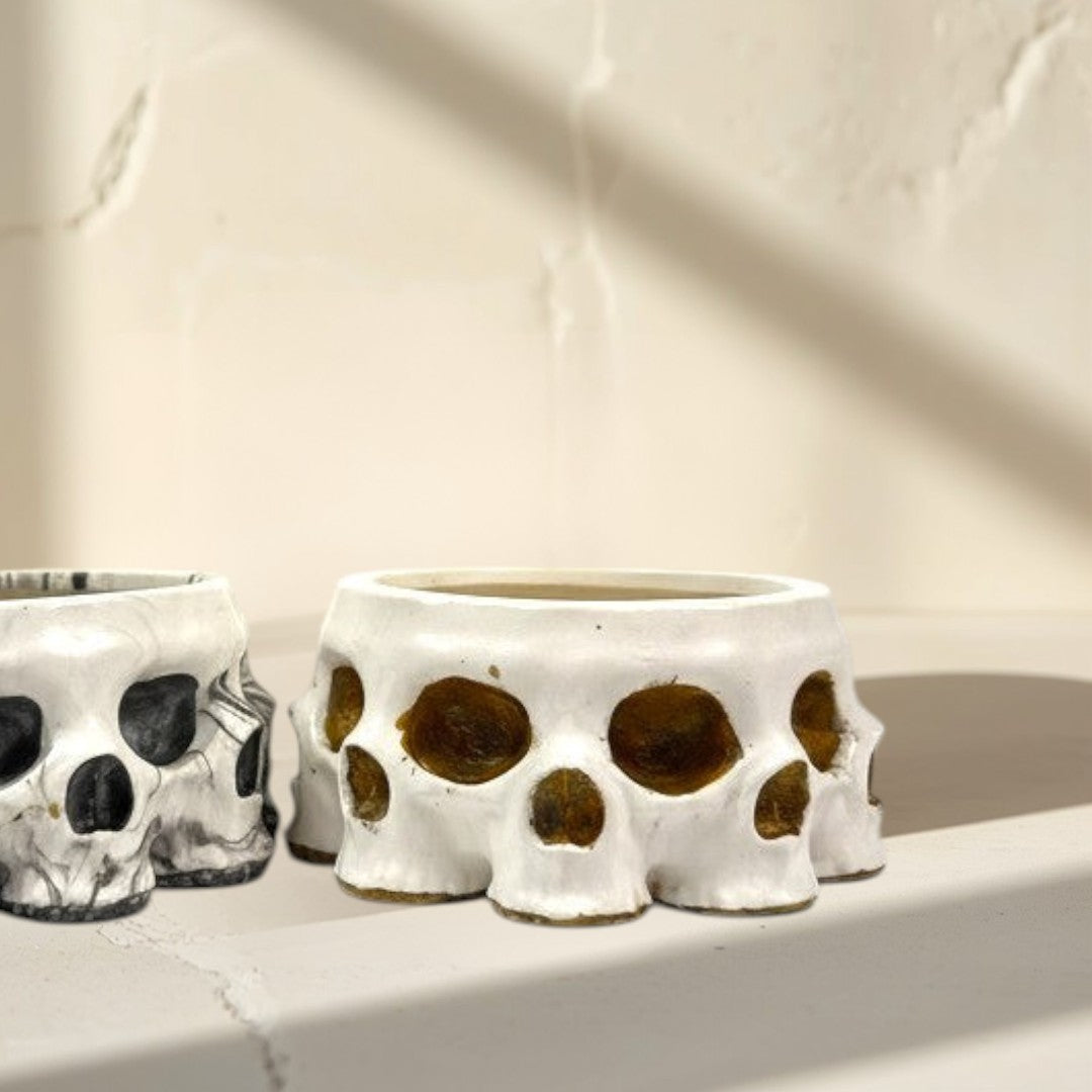 Doodlations Coffee Bar & Boutique skull concrete candle vessel with marbled black and white finish and a white finish with amber interior.