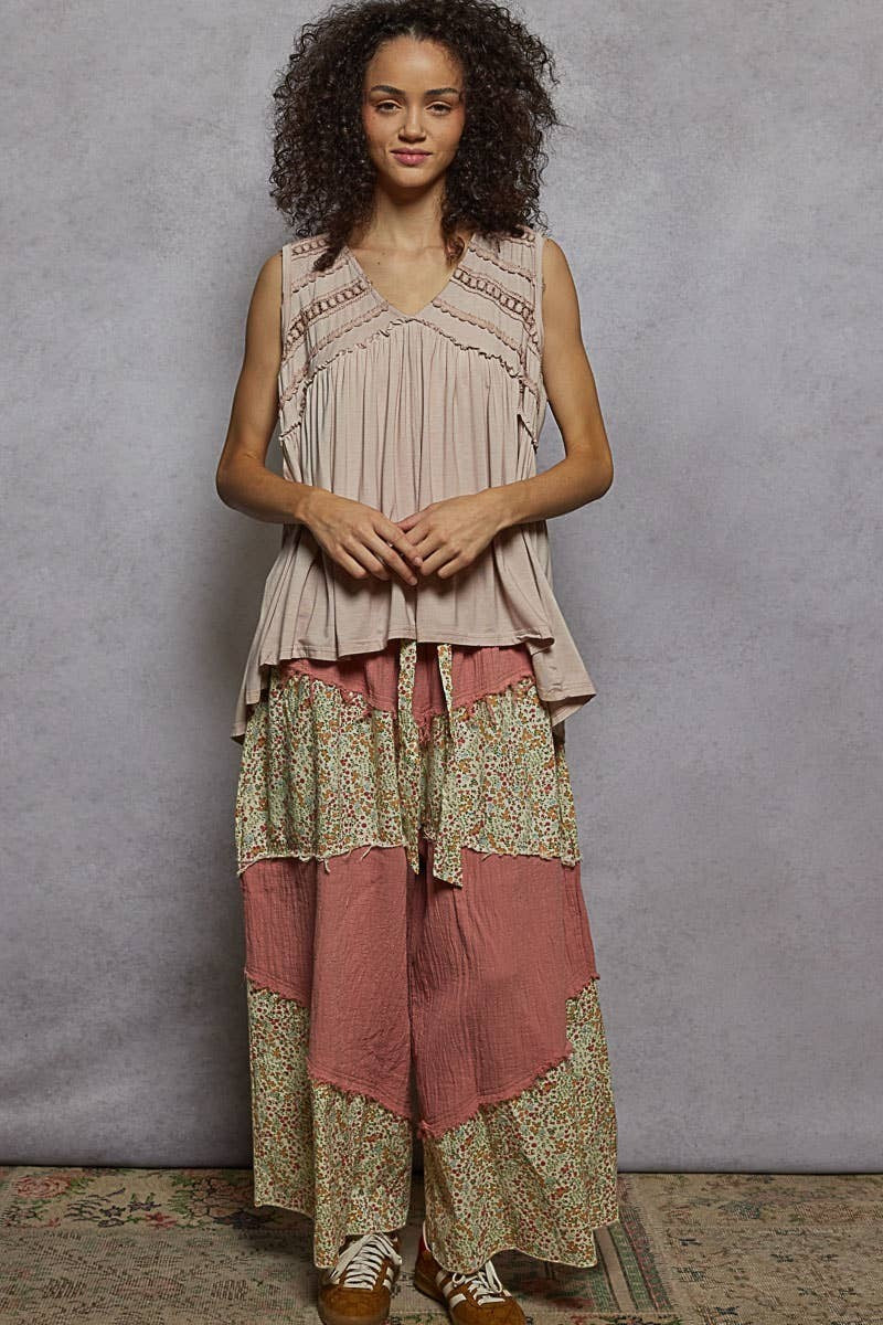 Doodlations Coffee Bar & Boutique sleeveless V-neck babydoll knit top with lace trim and raw edge details on a model.