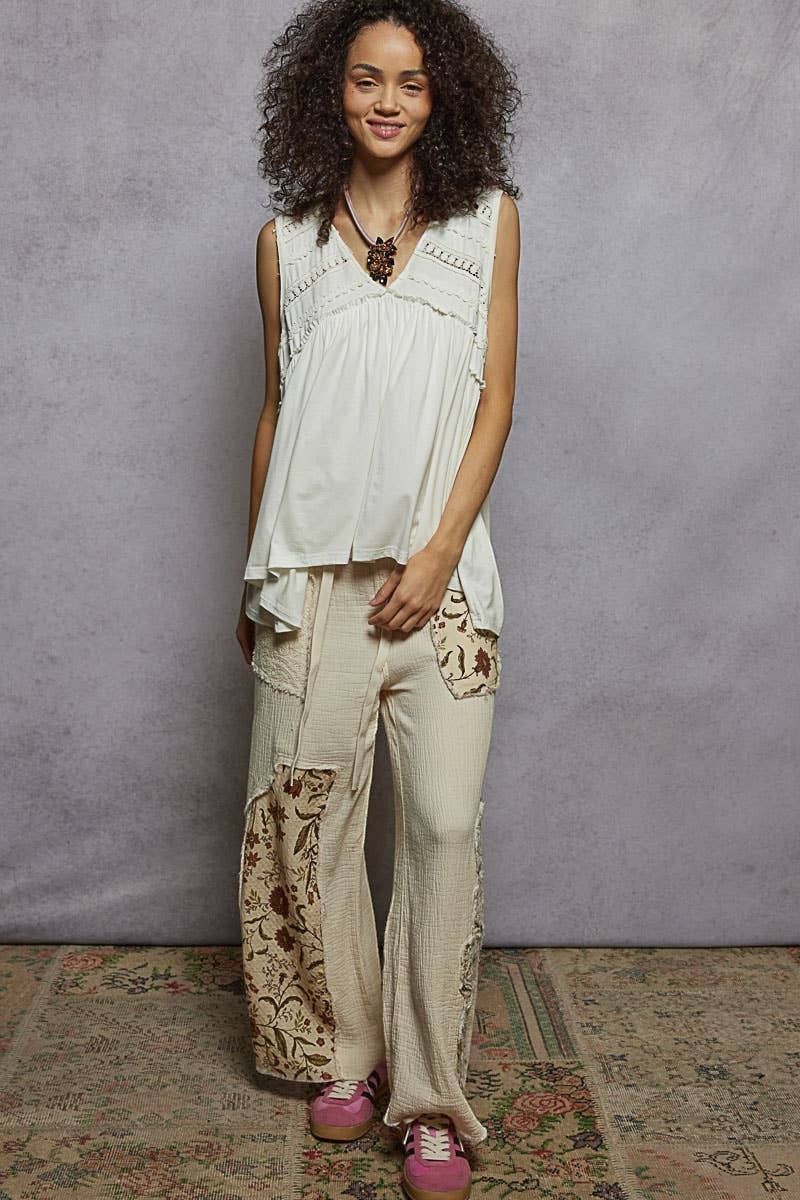 Doodlations Coffee Bar & Boutique sleeveless cream V-neck babydoll top with lace trim and ruffle details on a model