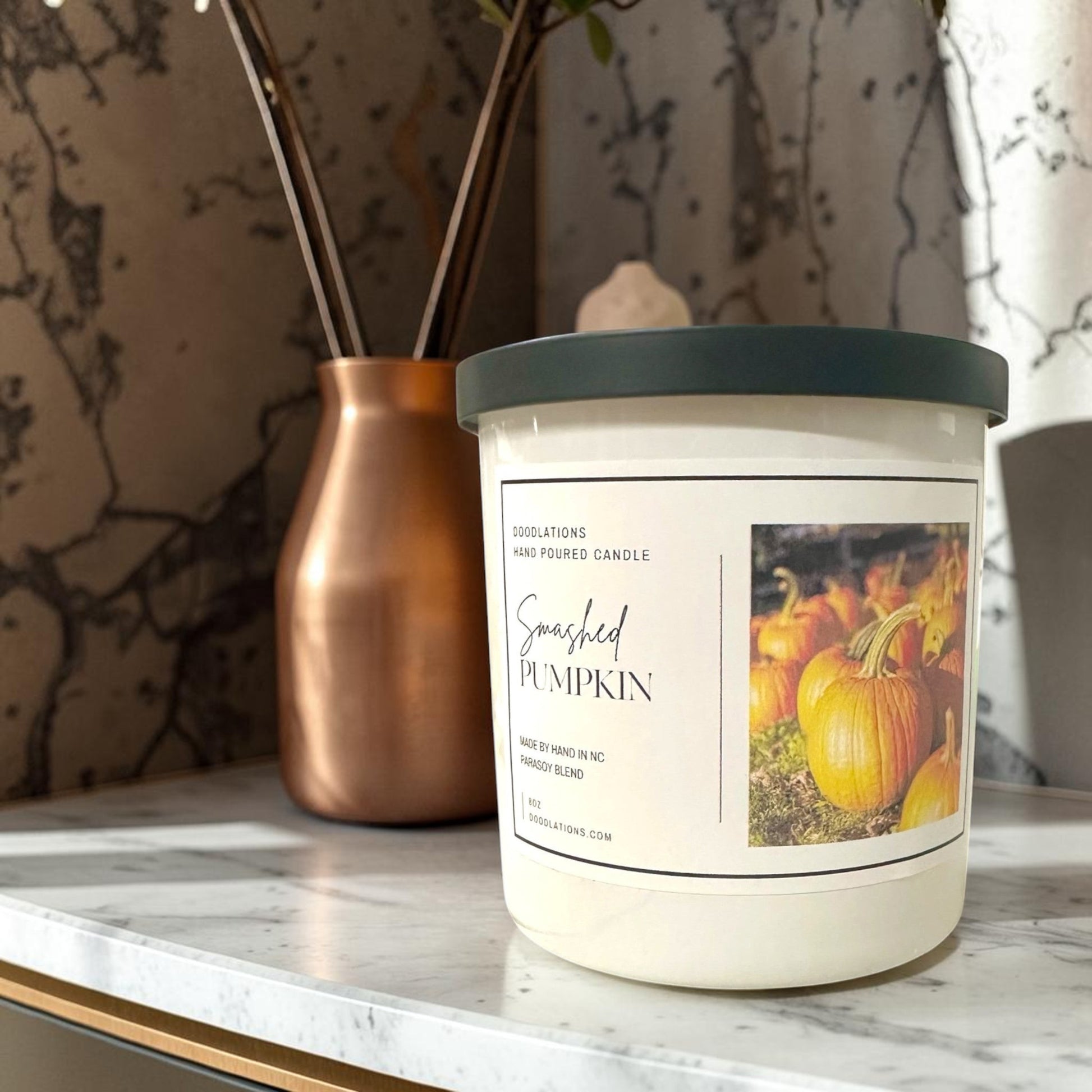 Doodlations Coffee Bar & Boutique Smashed Pumpkin hand-poured soy blend candle with a dark green lid.