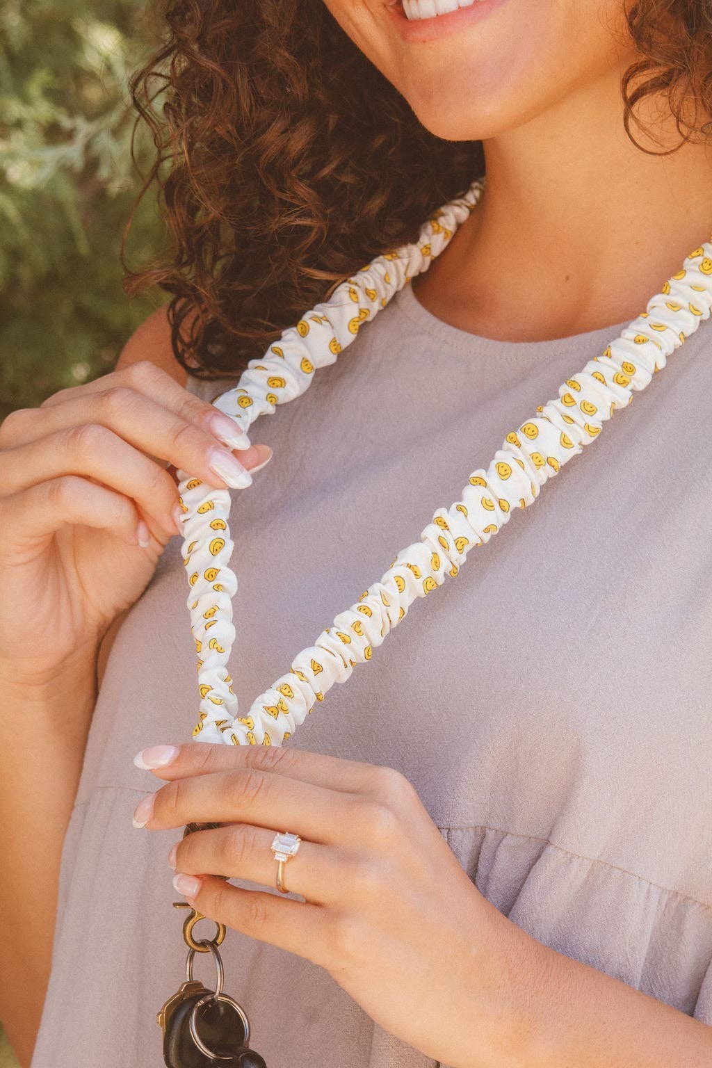 Doodlations Coffee Bar & Boutique No Worries lanyard in white luxe fabric with a yellow smiley face pattern