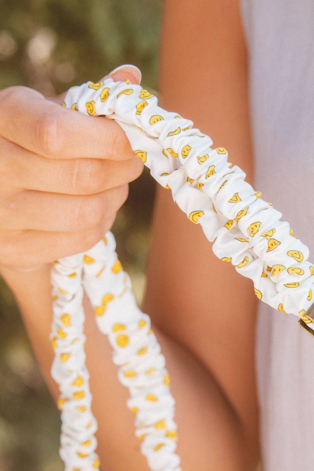 Doodlations Coffee Bar & Boutique No Worries lanyard in white luxe fabric with a yellow smiley face pattern