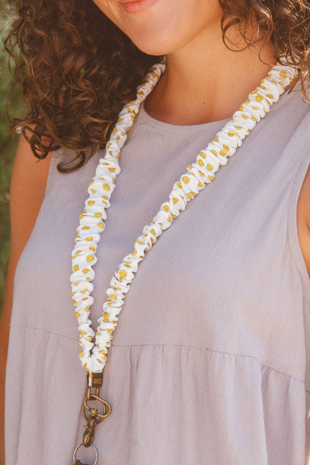 Doodlations Coffee Bar & Boutique No Worries lanyard in white luxe fabric with a yellow smiley face pattern
