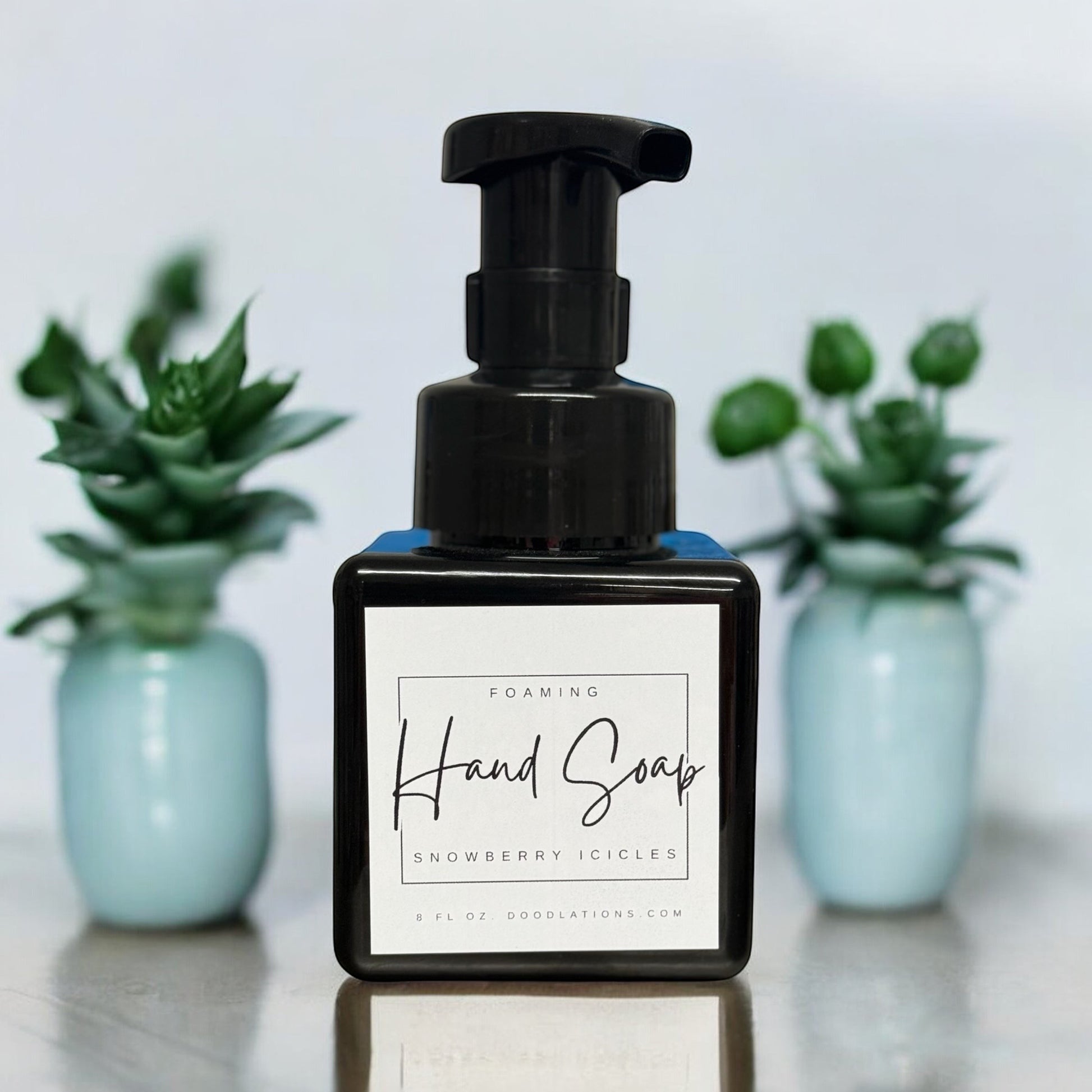 Doodlations Coffee Bar & Boutique Snowberry Icicles foaming hand soap in a black pump bottle with a white label.