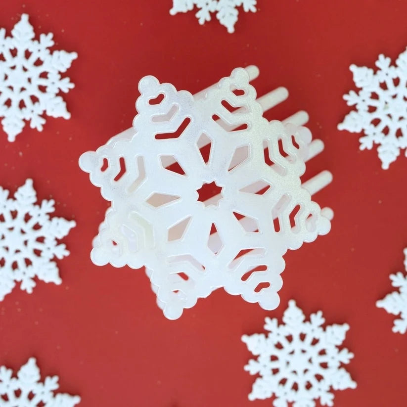 Doodlations Coffee Bar & Boutique white glitter snowflake hair clip with cutout details on a red background