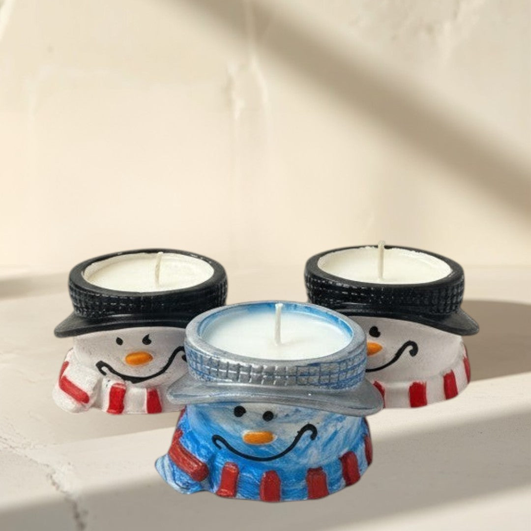 Doodlations Coffee Bar & Boutique snowman concrete tea light holders with white candles. One has a blue scarf, another a red scarf.