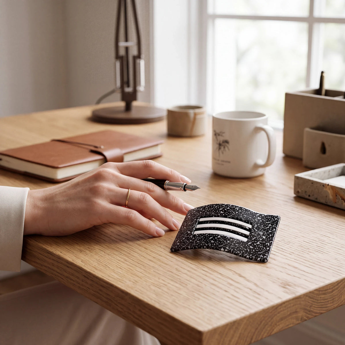 Doodlations Coffee Bar & Boutique Teleties flat rectangle hair clip with black and white speckled pattern on a desk