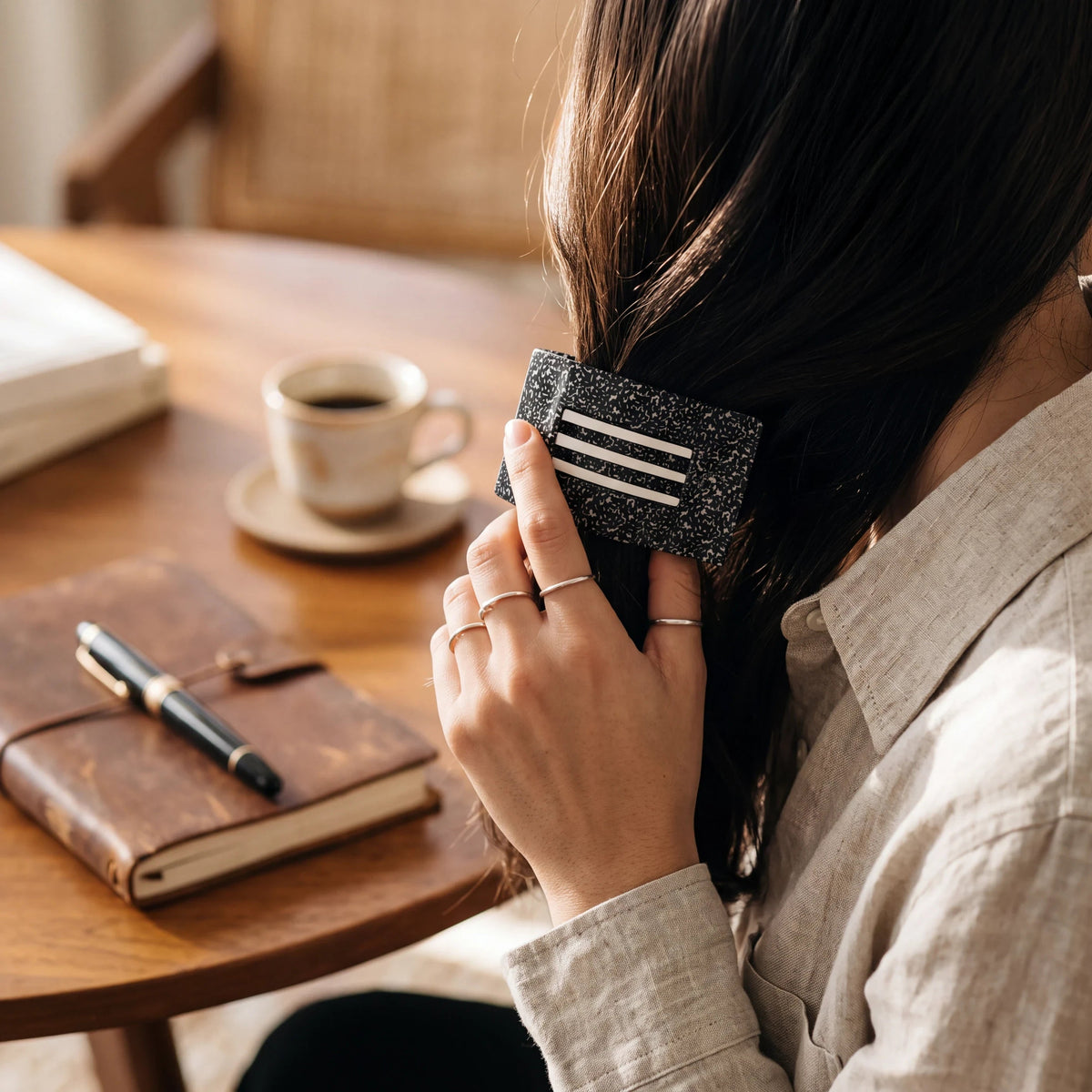 Doodlations Coffee Bar & Boutique Teleties flat rectangle hair clip with a black speckled pattern and white stripes.