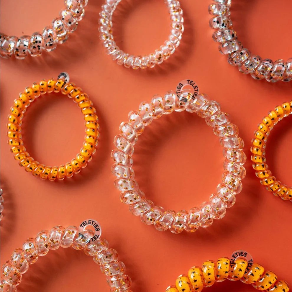 Doodlations Coffee Bar & Boutique Spooky Sparkles spiral hair ties in orange and clear with glitter on orange background