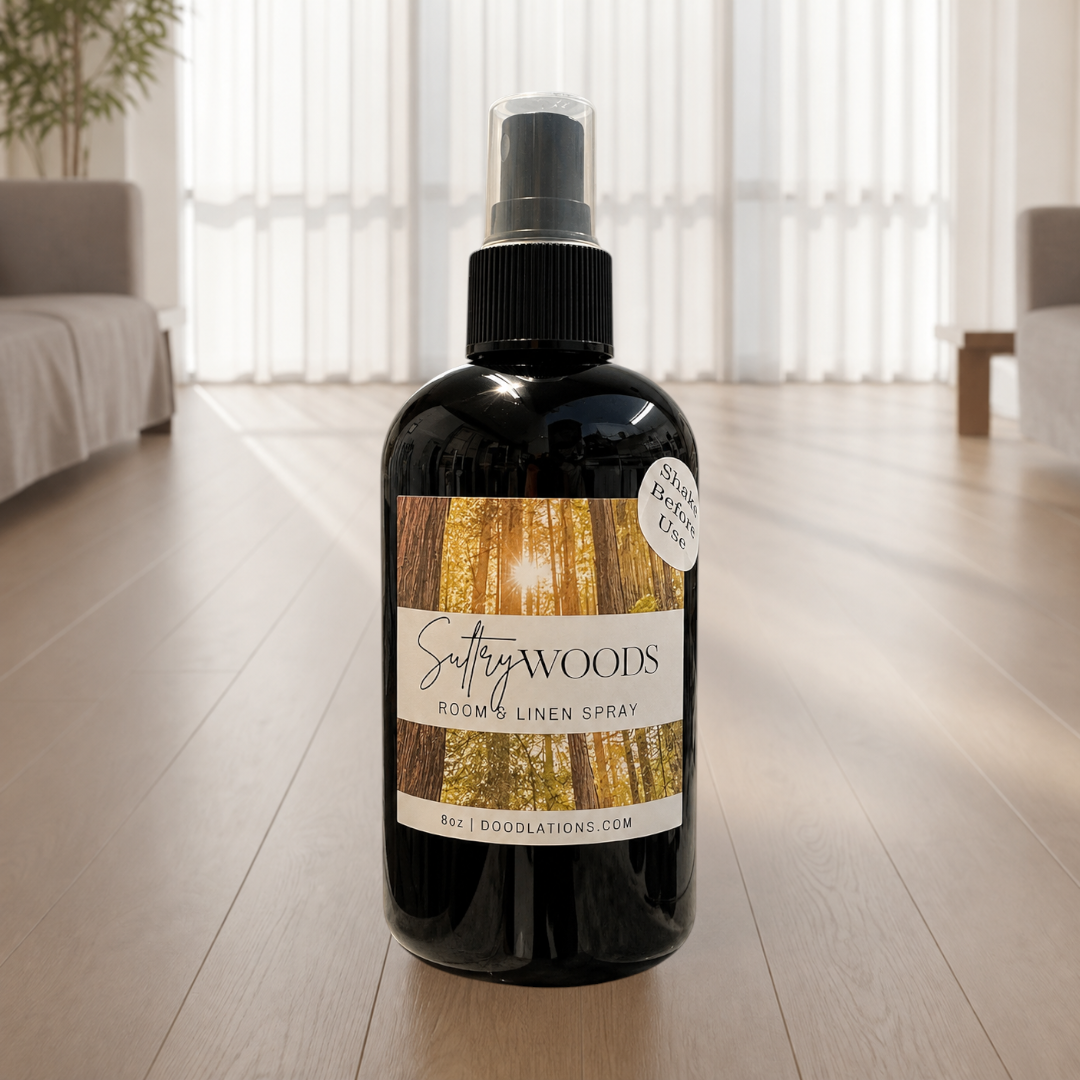 Doodlations Coffee Bar & Boutique Sultry Woods room and linen spray in a black bottle with a forest-themed label