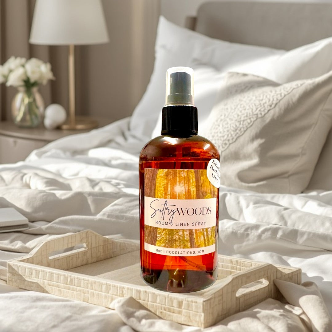 Doodlations Coffee Bar & Boutique Sultry Woods Room & Linen Spray in amber glass bottle with forest label. 8oz.