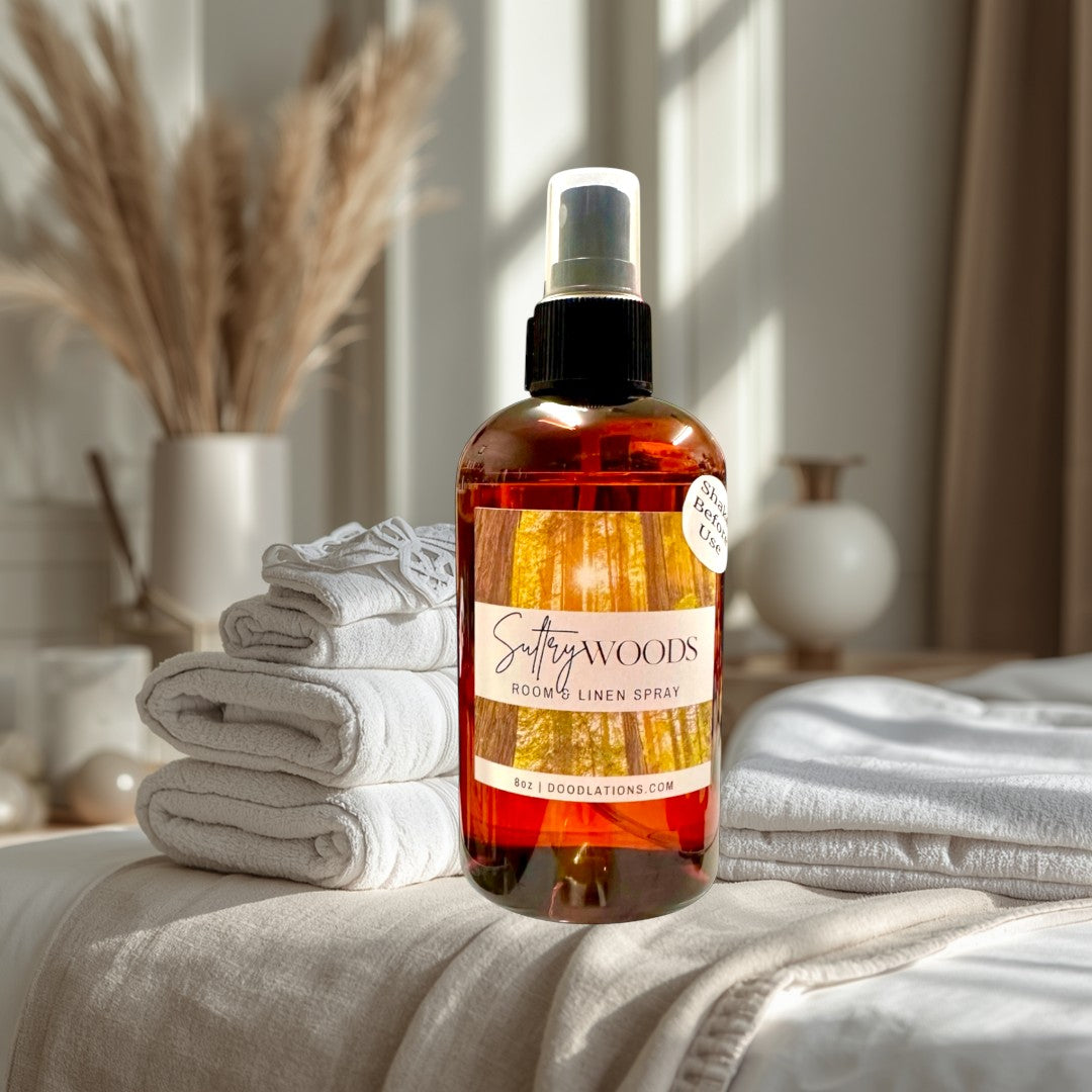 Doodlations Coffee Bar & Boutique Sultry Woods Room & Linen Spray in amber glass bottle with forest label.