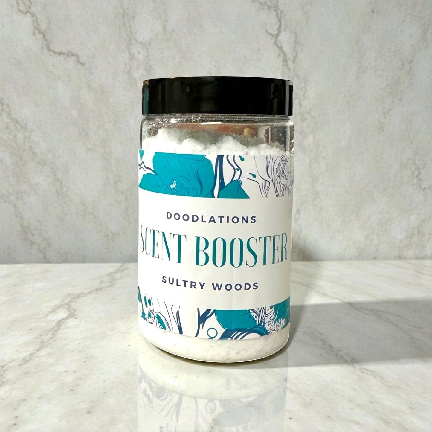 Doodlations Coffee Bar & Boutique Sultry Woods scent booster in a clear plastic jar with a black lid. White granules fill the jar.