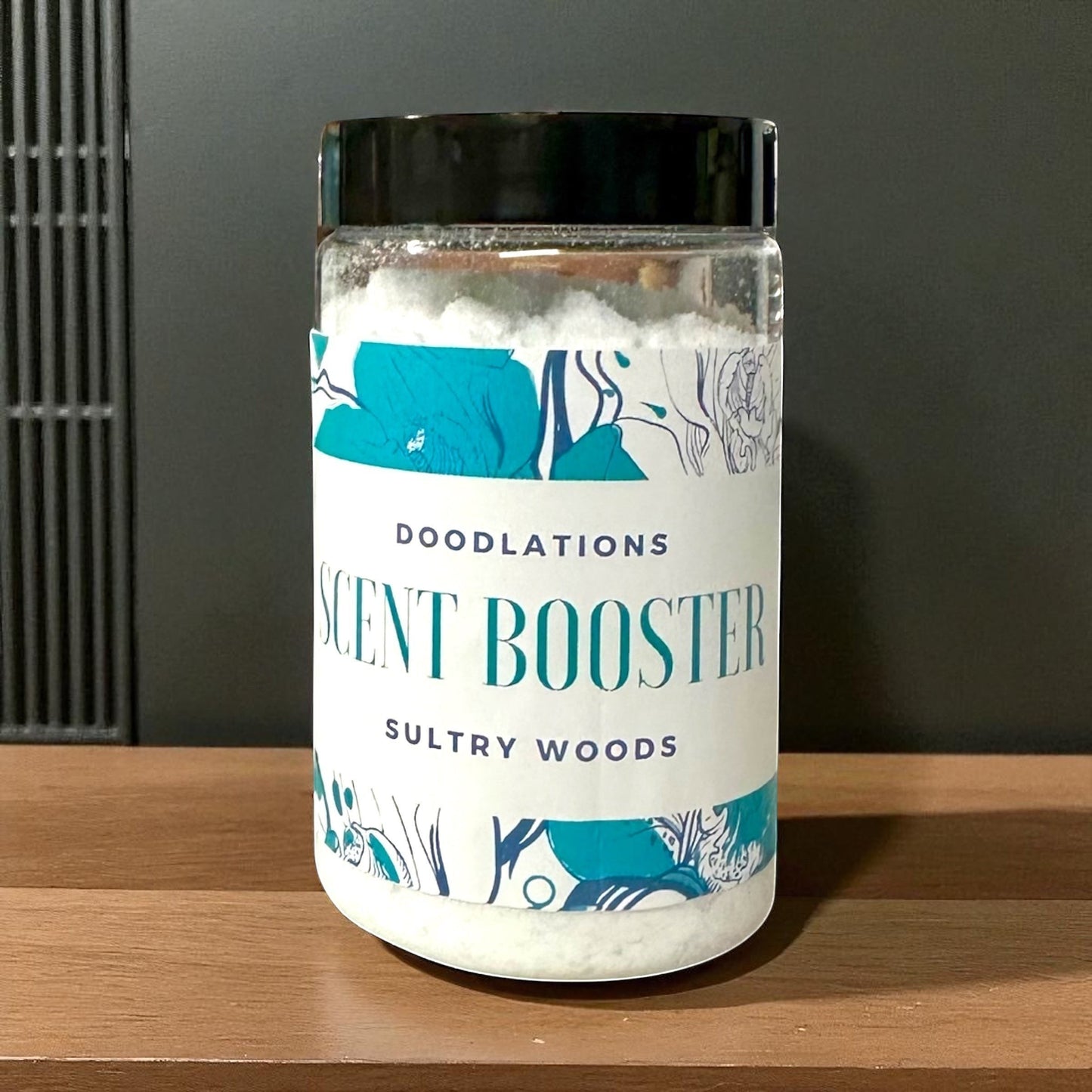 Doodlations Coffee Bar & Boutique Sultry Woods laundry scent boosters in a clear jar with a black lid. White granules inside.