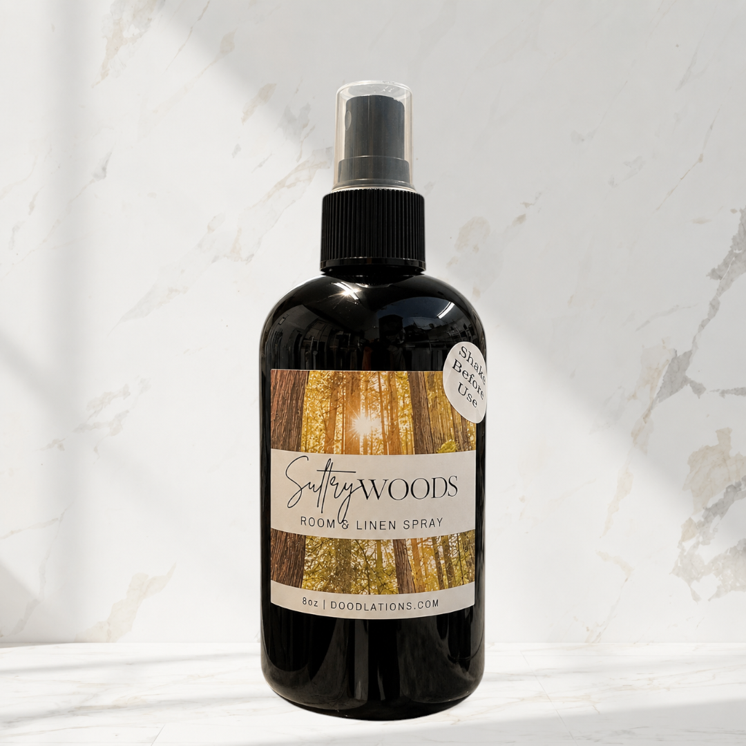 Doodlations Coffee Bar & Boutique Sultry Woods room and linen spray in an 8oz black bottle with a forest label.