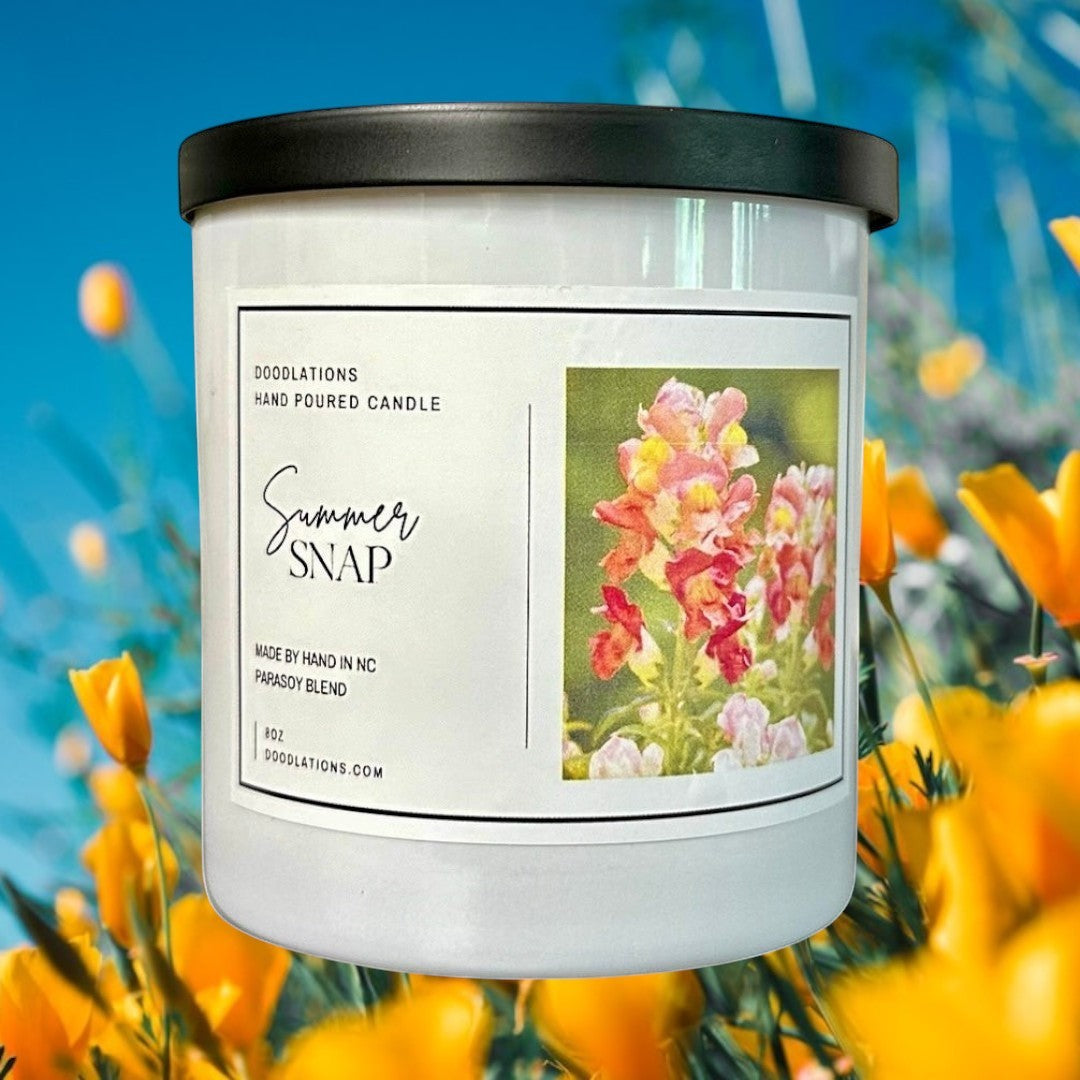 Doodlations Coffee Bar & Boutique Summer Snap hand-poured parasoy blend candle with floral-fruity scent. White jar, black lid.