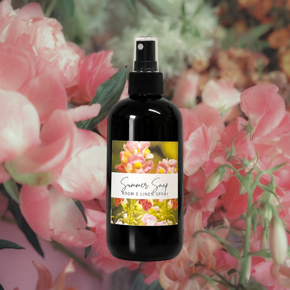 Doodlations Coffee Bar & Boutique Summer Snap room and linen spray in a black bottle against a floral background.