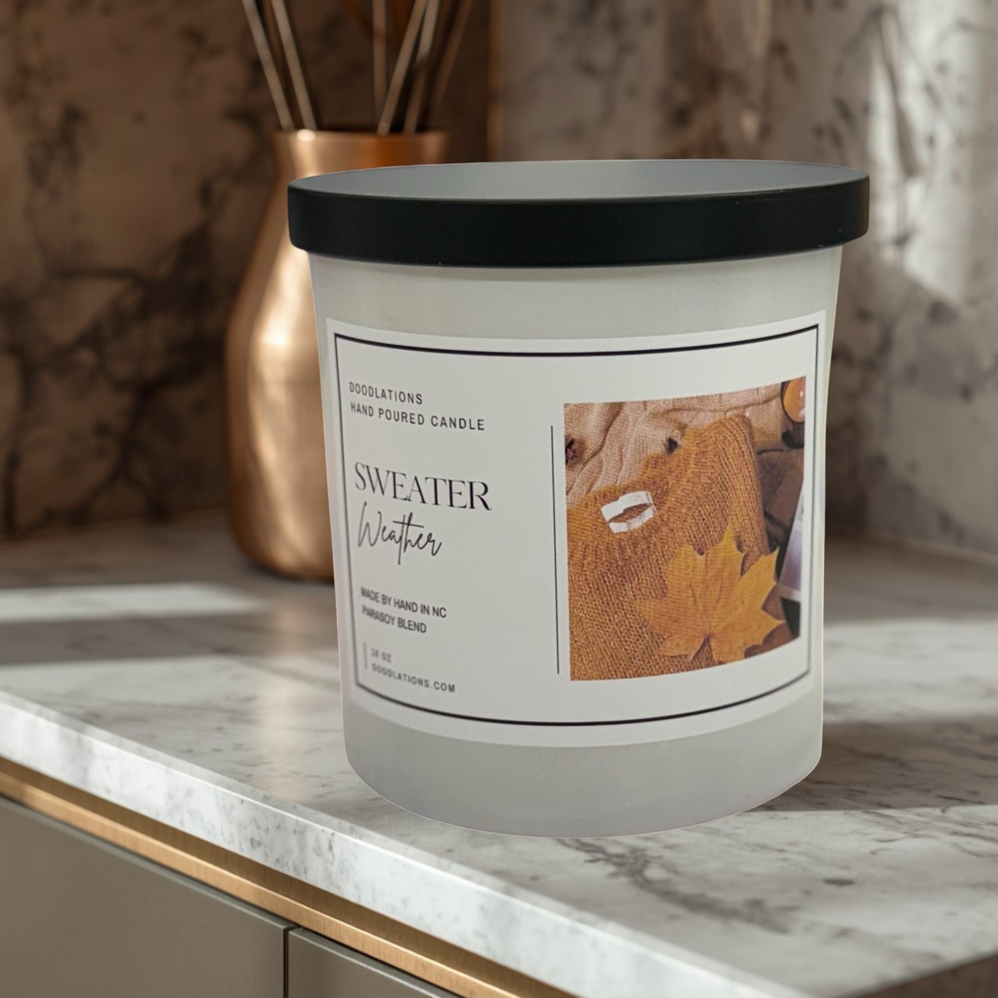 Doodlations Coffee Bar & Boutique Sweater Weather hand-poured soy blend candle with autumn leaf imagery.