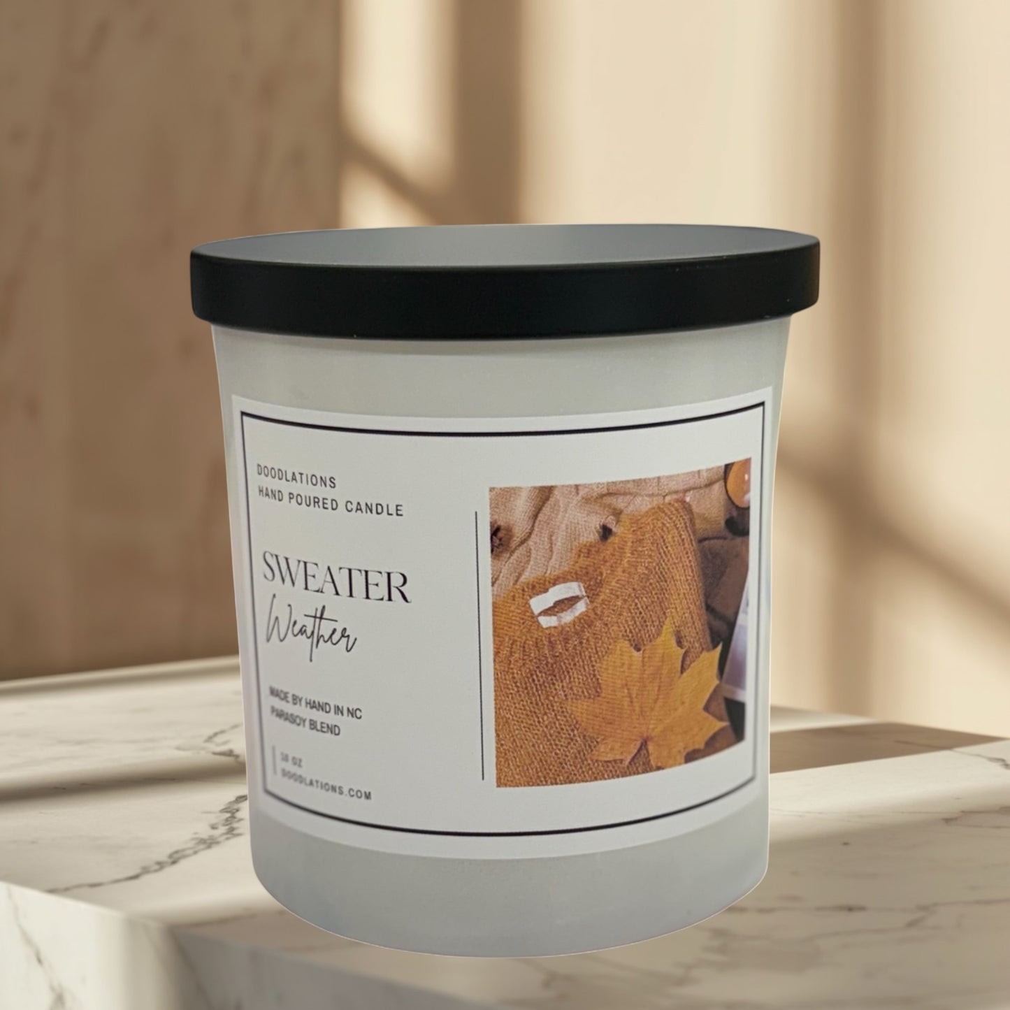 Doodlations Coffee Bar & Boutique Sweater Weather hand-poured soy blend candle with autumn leaf imagery.