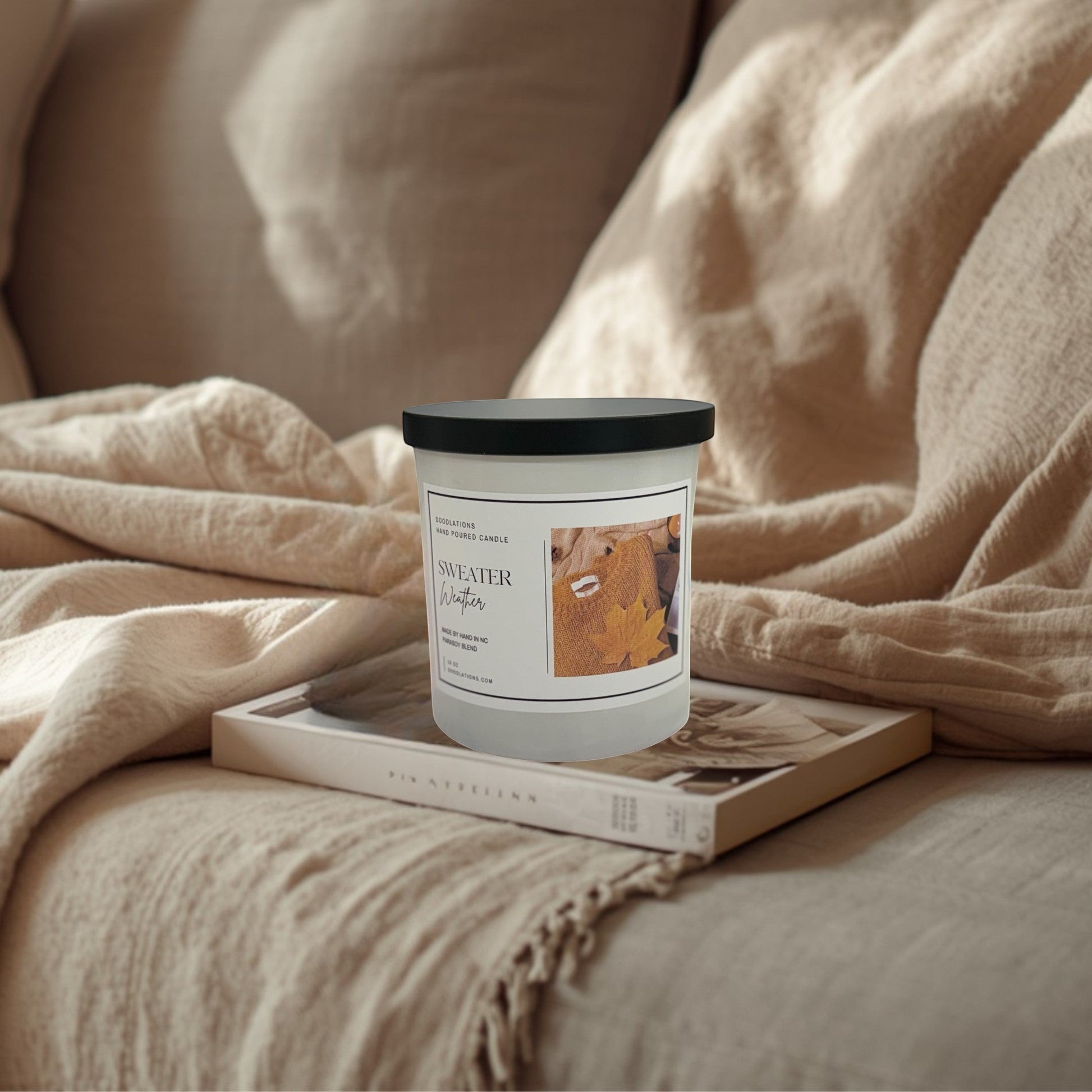 Doodlations Coffee Bar & Boutique Sweater Weather hand-poured soy blend candle with autumn leaf imagery.
