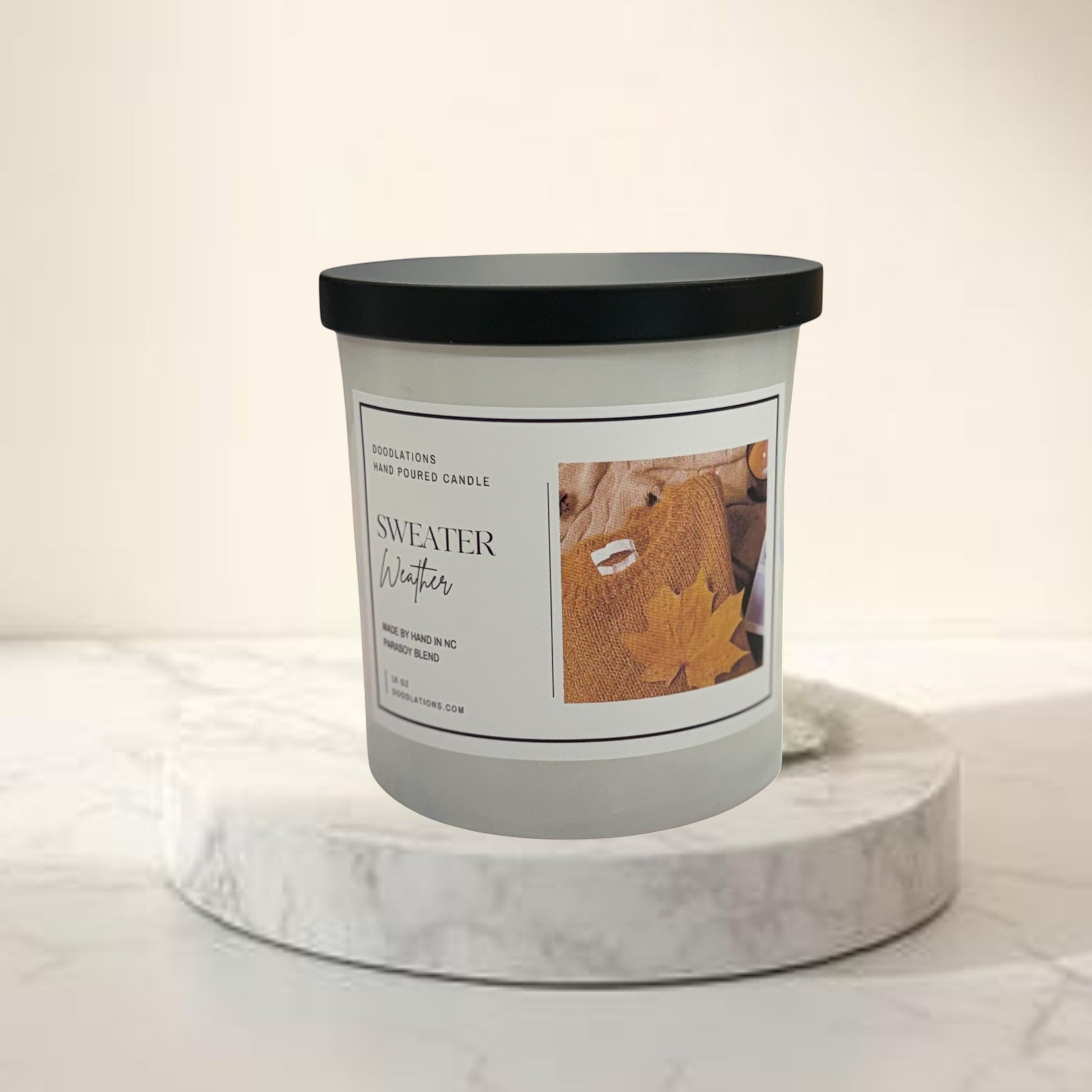 Doodlations Coffee Bar & Boutique Sweater Weather hand-poured soy blend candle with autumn leaf imagery.