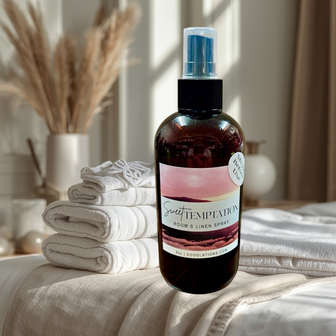 Doodlations Coffee Bar & Boutique Sweet Temptation room and linen spray in amber bottle with pink label. Tropical scent.