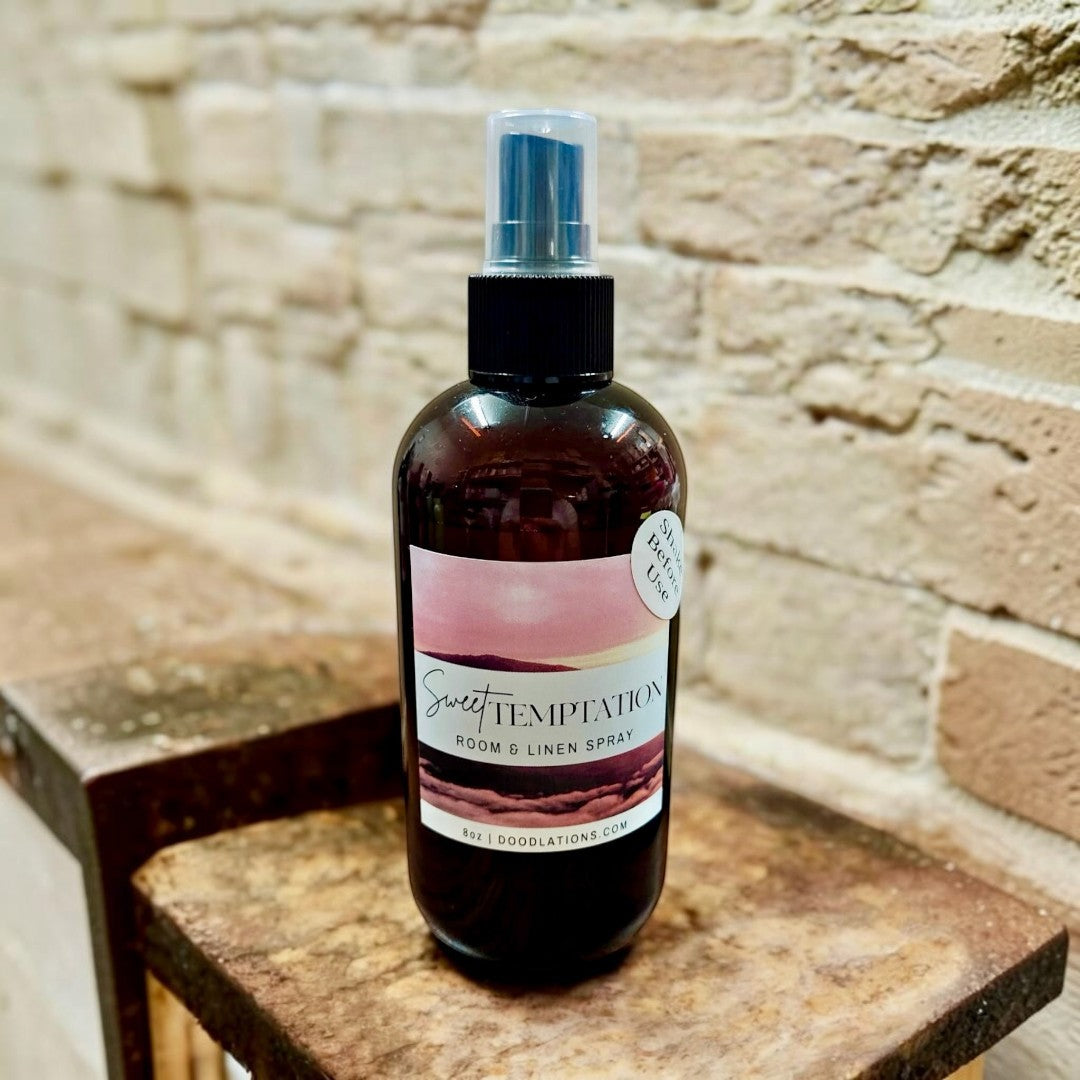 Doodlations Coffee Bar & Boutique Sweet Temptation room and linen spray in an amber bottle with a tropical label.