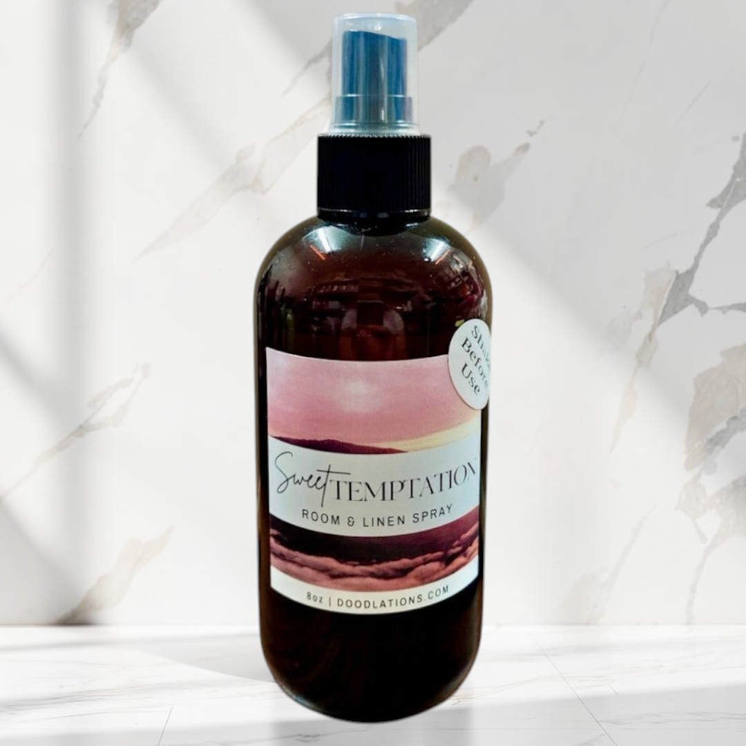 Doodlations Coffee Bar & Boutique Sweet Temptation room and linen spray in a dark amber bottle with a tropical label.
