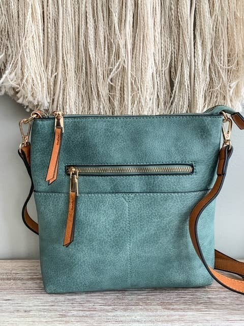 Doodlations Coffee Bar & Boutique teal vegan leather crossbody bag with gold-tone hardware and tan accents.